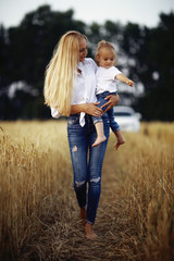 warm portrait of mother and daughter in country style in the field