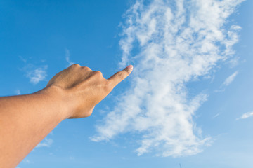 Asian man's index finger points to the bright blue sky with whit