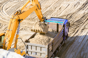 Excavator loading truck with sand