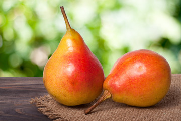 two pears on a dark wooden table with  blurred background