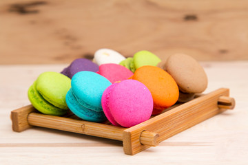 Colorful  macaroons in stack on light wooden background
