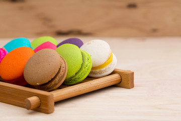 Colorful  macaroons in stack on light wooden background