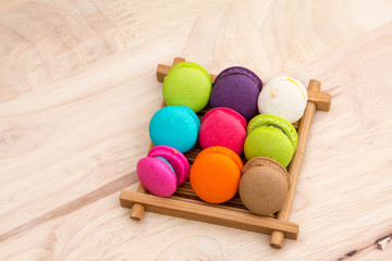 Colorful  macaroons in stack on light wooden background