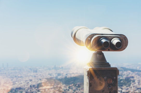 Touristic telescope look at the city view of Barcelona, close up old metal binoculars background overlooking the mountain, hipster coin operated in panorama observation nature blue sky, mockup flare