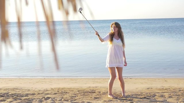 Beautiful young girl doing selfie on sea background. HD