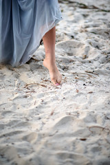 beautiful girl's foot on the sand. young girl walking on the beach