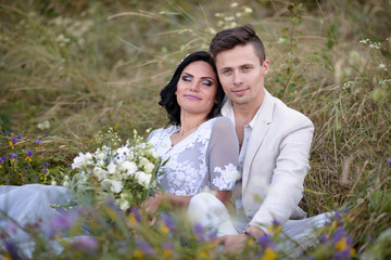 Young couple in love outdoor. Elegant bride and groom posing together outdoors on a wedding day. bride and groom in the Park. young couple in the woods. young couple in the grass. couple walking