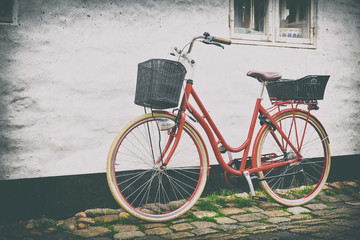 Fototapeta na wymiar Retro vintage red bicycle on cobblestone street in the old town.