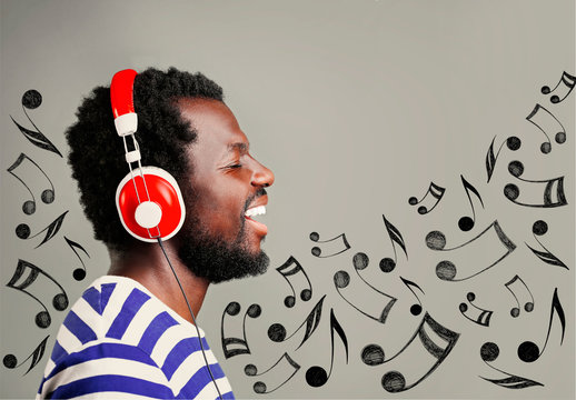 Young afroamerican man listening music. Musical notes design on color background.