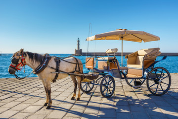 Fototapeta na wymiar Horse carriage for transporting tourists in old port of Chania on Crete, Greece
