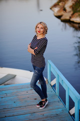 Obraz premium blonde in a striped sweater on a background of water