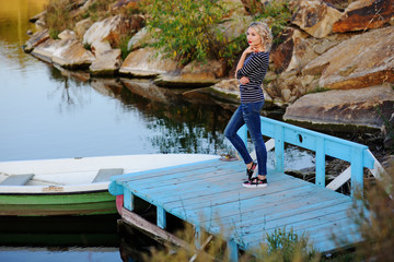 blonde in a striped sweater on a background of water
