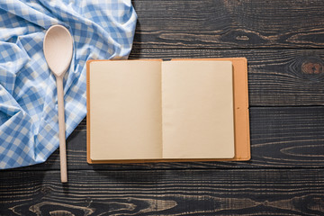 open recipe book, on dark wooden background, view from the top