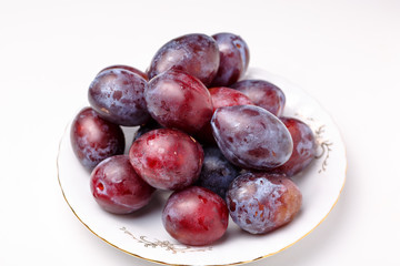 Fresh plums lying on a white plate
