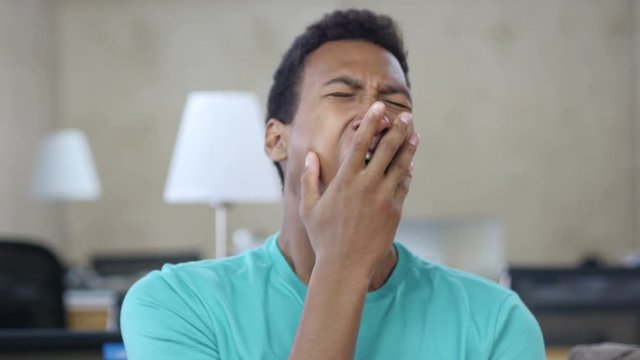 Sleepy Yawing Black Young Man in Office, Portrait