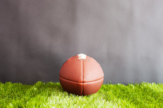 Vintage football over grass and black background