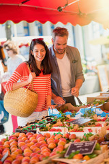 Handsome couple looking fruit in a market in summer