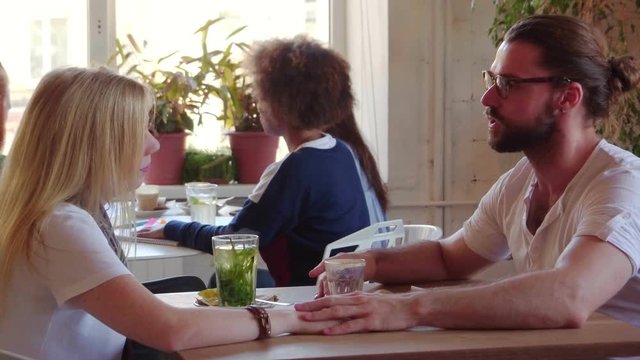Hipster with his girlfriend on a romantic date in a cute little Cafe