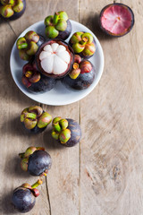 Mangosteen and cross section showing the thick purple skin and w