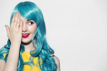 Pop art woman portrait wearing blue curly wig and bright yellow