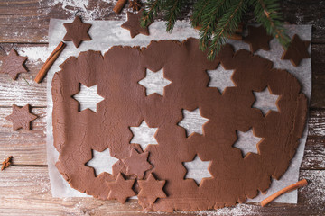 Baking Christmas cookies.  Roll out the dough to cut out stars on a wooden background