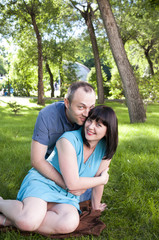 Fototapeta premium A man hugs a woman on the lawn 