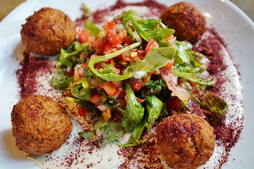 A plate of falafel balls with salad