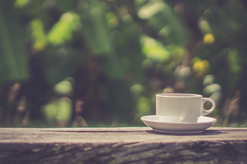 Retro style or Vintage Style, Black Coffee cup Put on a stump or wood table in the garden sunny morning.
