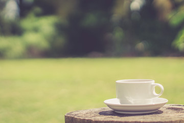 Retro style or Vintage Style, Black Coffee cup Put on a stump or wood table in the garden sunny morning.
