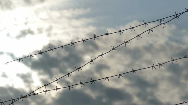 Barbed wire against the blue sky clouds video prison