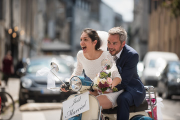  Newlyweds having fun on a decorated vintage scooter