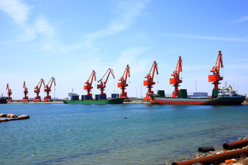 In freight terminal, gantry crane and cargo ships are in loading