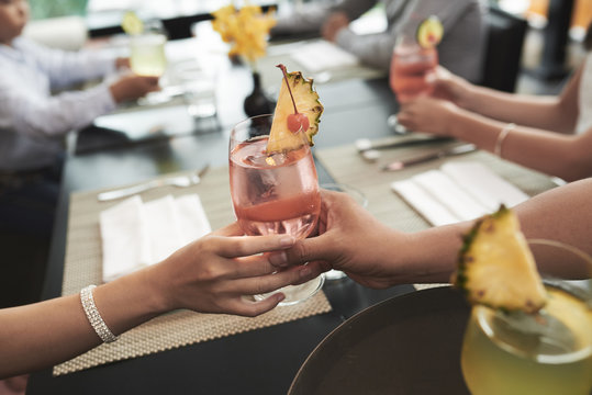 Close-up image of person giving cocktail at dinner table