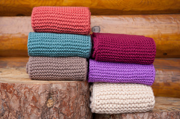 Six roll knitted scarf on wooden background