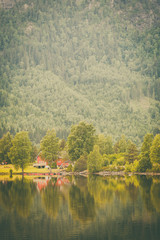 Fototapeta na wymiar Norwegian country houses in mountains on lake shore