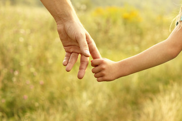 hands of parent and child in nature