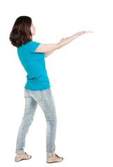 Back view of  pointing woman. beautiful brunette  girl in jeans. Rear view people collection.  backside view of person.  Isolated over white background.