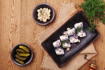 Rolled herring in vinegar, served with onions and pickles.