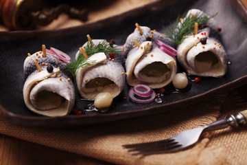 Rolled herring in vinegar, served with onions and pickles.