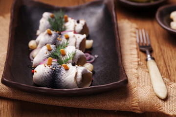 Rolled herring in vinegar, served with onions and pickles.