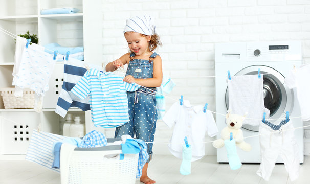 Child Fun Happy Little Girl  To Wash Clothes And Laughs In Laund