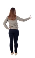 Back view of  woman thumbs up. Rear view people collection. backside view of person. Isolated over white background. slender blonde in a jeans shows the symbol of success or hitchhiking. left-handed