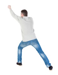 back view of standing man pulling a rope from the top or cling to something. guy watching. Rear view people collection.  backside view of person.  Isolated over white background.