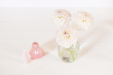 Chrysanthemum in vase, perfume, lipstick on white background. Casual creative lady home office.
