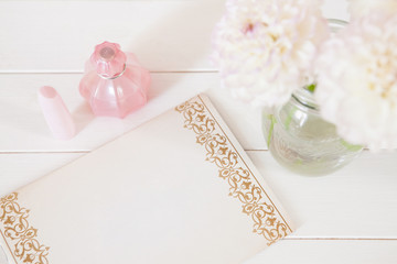 Chrysanthemum in vase, perfume, lipstick, pen, paper for notes o