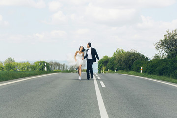 wedding happy couple running on road