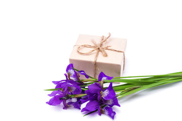 bouquet of purple iris flowers and a gift on a white background