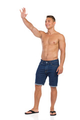 Fototapeta premium Waving Half Naked Fit Man In Jeans Shorts