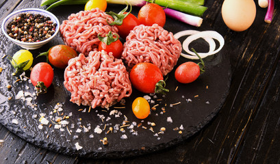 raw minced meat, vegetables with salt and spices, selective focus