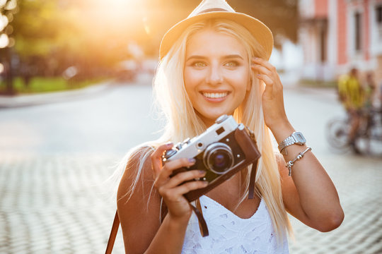Close up portrait of a smiling girl holding retro camera